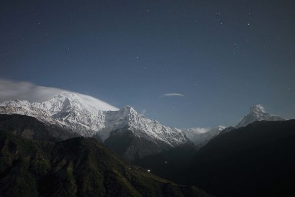Berglandschaft bei Nacht mit Sternenhimmel im Schwarzwald, Blick auf die verschneiten Gipfel und dun.